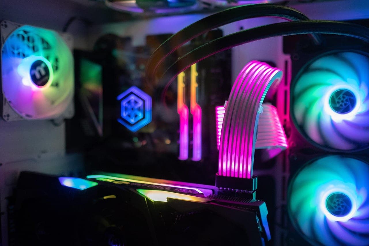 Gaming-PC mit farbig beleuchteten Lüftern und Grafikkarte im Dunkeln — Sinnbild für einen Gaming-Clan