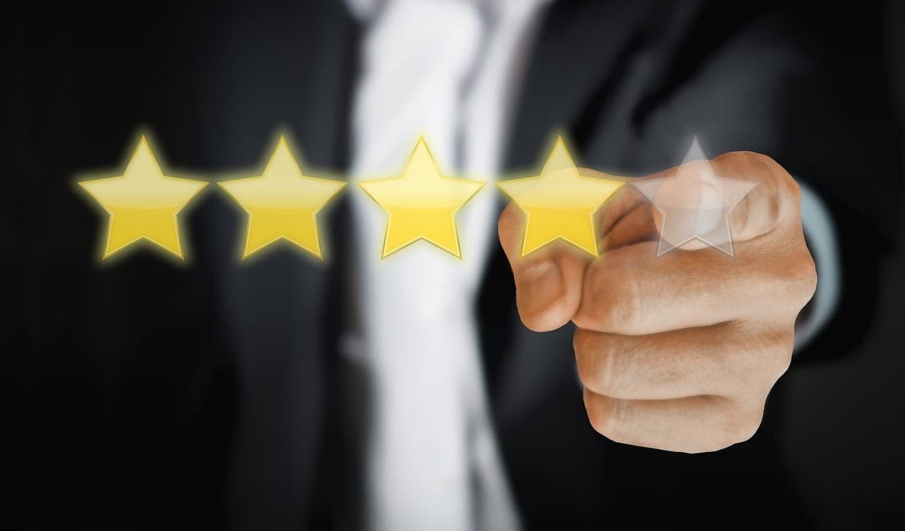 Hand aktiviert den fünften von fünf goldenen Sternen — Sinnbild für Kundenbewertungen und Social Proof